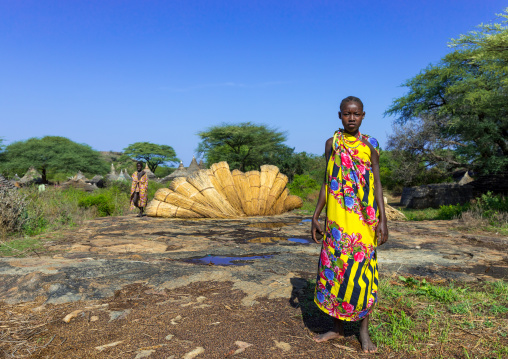 Larim tribe girls in front of thatch used to make the houses roofs, Boya Mountains, Imatong, South Sudan