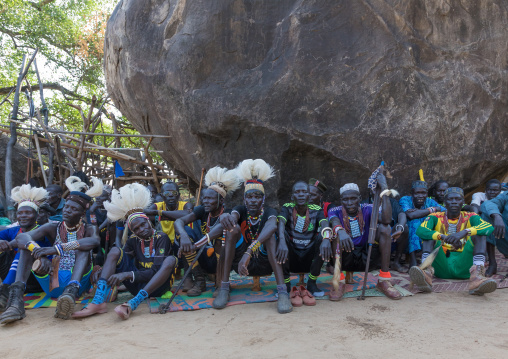 Larim tribe men under a giant rock during a wedding celebration, Boya Mountains, Imatong, South Sudan