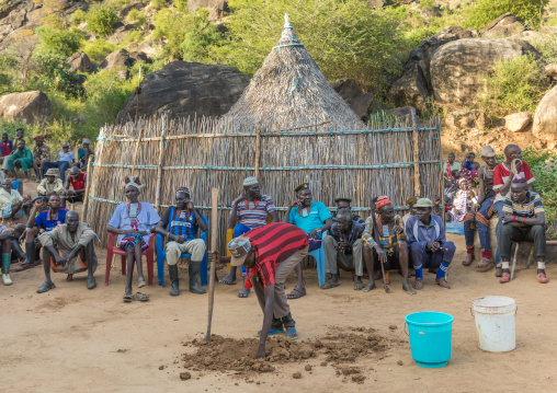 Larim tribe man making a hole to welcome a jar during a wedding ceremony, Boya Mountains, Imatong, South Sudan