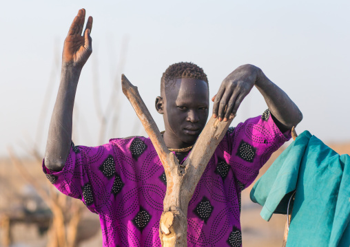 A Mundari tribe man mimics the position of horns of his favourite cow, Central Equatoria, Terekeka, South Sudan