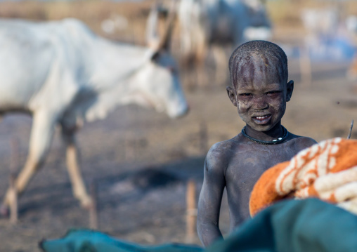 Smiling Mundari tribe boy covered in ash to repel flies and mosquitoes in a cattle camp, Central Equatoria, Terekeka, South Sudan