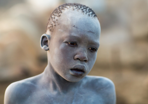Portrait of a Mundari tribe boy covered in ash to repel flies and mosquitoes in a cattle camp, Central Equatoria, Terekeka, South Sudan