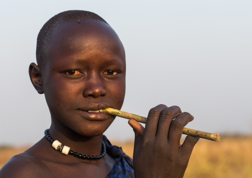 Mundari tribe woman using a wooden toothbrush, Central Equatoria, Terekeka, South Sudan