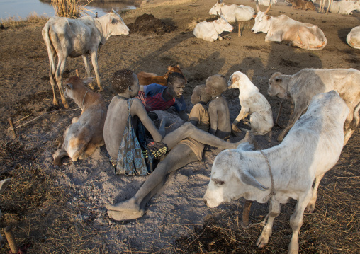 Mundari tribe boys taking care of a campfire made with dried cow dungs to repel flies and mosquitoes, Central Equatoria, Terekeka, South Sudan