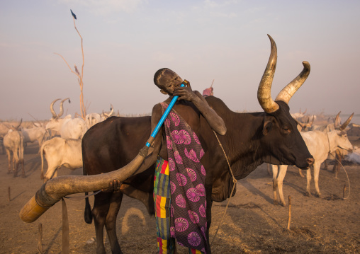 Mundari tribe man blowing in a cow horn, Central Equatoria, Terekeka, South Sudan