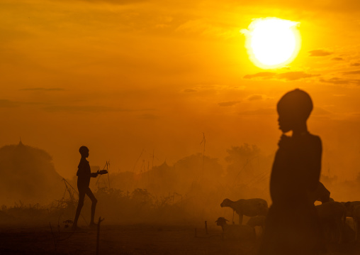 Mundari tribe boys taking care of the bonfires made with dried cow dungs to repel flies and mosquitoes, Central Equatoria, Terekeka, South Sudan