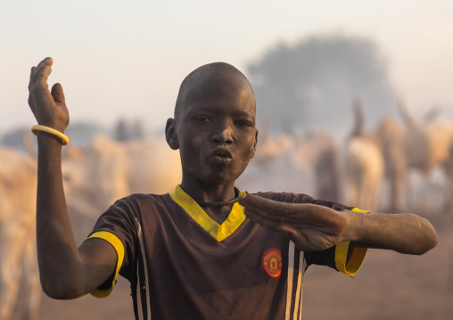A Mundari tribe boy mimics the position of horns of his favourite cow, Central Equatoria, Terekeka, South Sudan