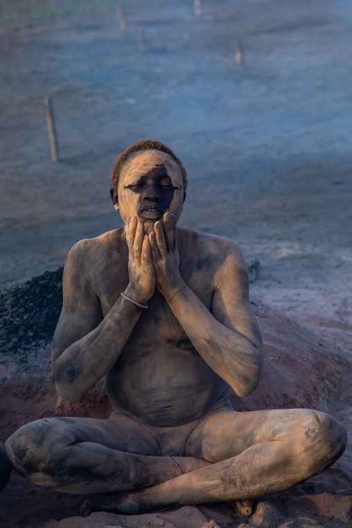 Mundari tribe man covering his body in ash to repel flies and mosquitoes, Central Equatoria, Terekeka, South Sudan