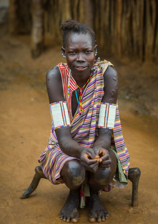 Portrait of a Larim tribe woman sit on a wooden seat, Boya Mountains, Imatong, South Sudan
