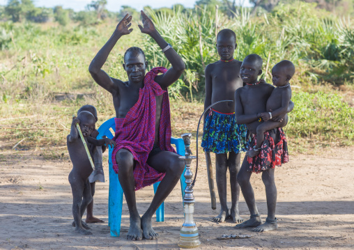 A Mundari tribe man with his children mimics the position of horns of his favourite cow, Central Equatoria, Terekeka, South Sudan