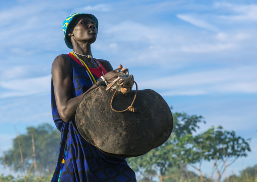 Mundari tribe woman carrying a huge bell while celebrating a wedding, Central Equatoria, Terekeka, South Sudan