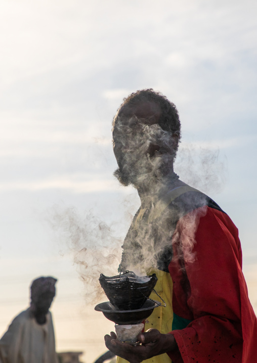 Man with insence burning during the friday sufi celebration at sheikh Hamad el Nil tomb, Khartoum State, Omdurman, Sudan