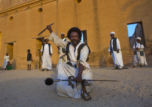 Sudan, Kassala State, Kassala, beja tribe men dancing in front of the khatmiyah mosque at the base of the taka mountains