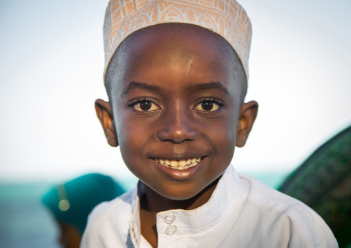 Tanzania, Zanzibar, Kizimkazi, young muslim boy in school uniform on beach