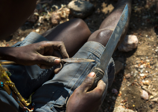 Tanzania, Serengeti Plateau, Lake Eyasi, hadzabe bushman making the arrow for a hunting bow