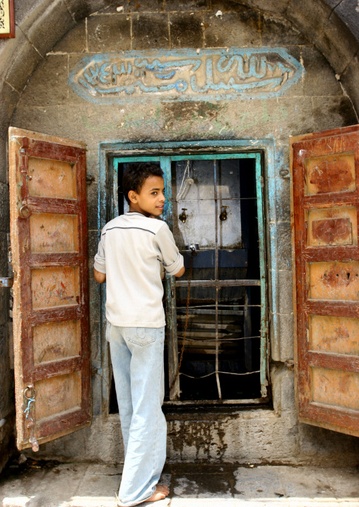 Arabic Boy In Tshirt And Jeans Drinking Water From A Street Fountain, Sanaa, Yemen