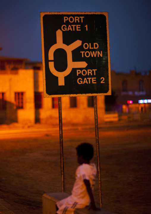 Eritrean girl standing below a road sign at night, Northern Red Sea, Massawa, Eritrea
