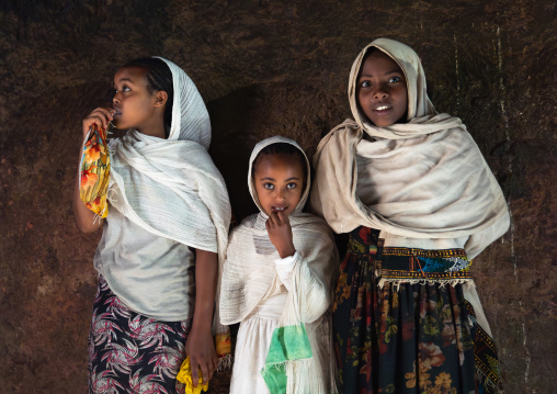 Three ethiopian girls inside Bilbaia Giorgis Rock Hewn Church, Amhara Region, Lalibela, Ethiopia