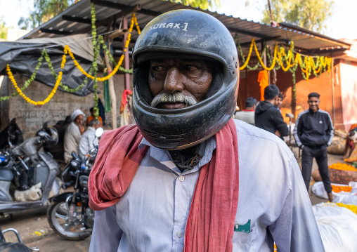 Indian man with a motorbike helmet in the market, Rajasthan, Jaipur, India