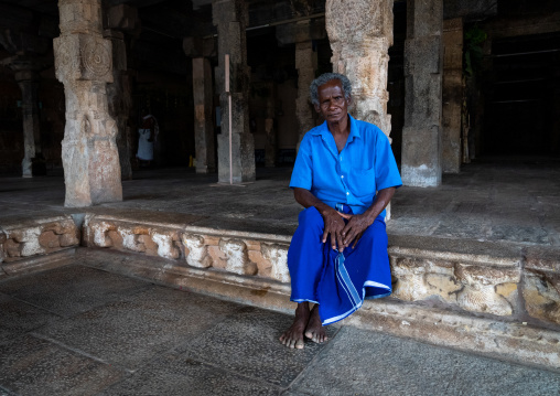 Portrait of an indian man dressed in blue inside Sri Ranganathaswamy Temple, Tamil Nadu, Tiruchirappalli, India