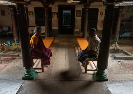 INdian people sit on benches in a Chettiar mansion, Tamil Nadu, Kanadukathan, India