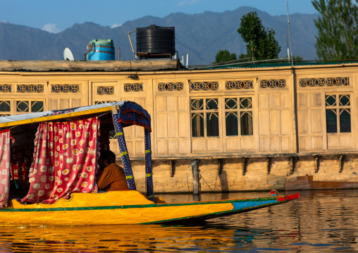 Shikara boat passing in front of a houseboat on Dal Lake, Jammu and Kashmir, Srinagar, India