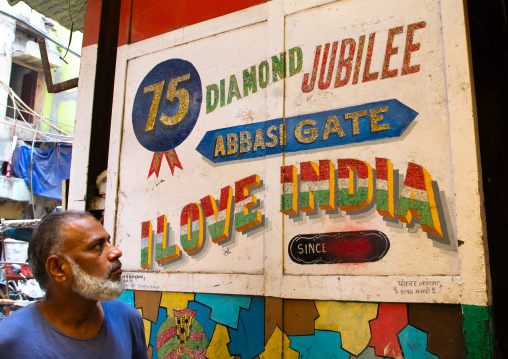 Indian man looking at a billboard for the diamond jubilee, Delhi, New Delhi, India