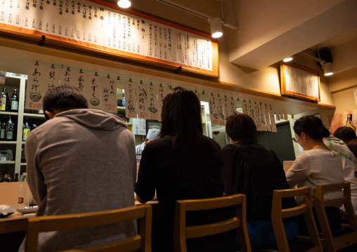 Guests sit in a sushi restaurant, Kyushu region, Fukuoka, Japan