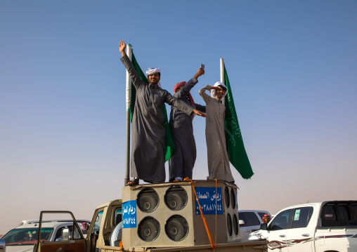 Saudi men dancing on a car during King Abdul Aziz Camel Festival, Riyadh Province, Rimah, Saudi Arabia