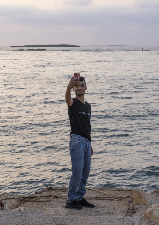 Young man taking selfie in front of the sea, North Governorate, Tripoli, Lebanon