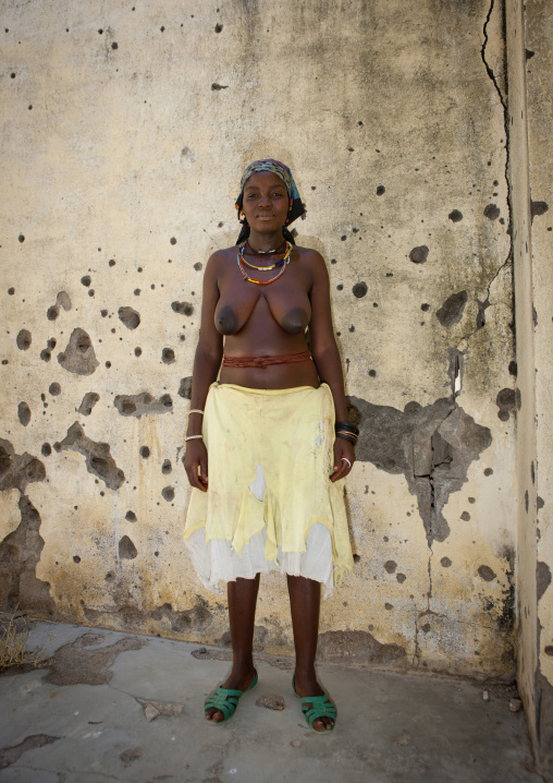 Woman In Front Of A Wall Riddled With Bullet Impacts, Village Of Chitado, Angola