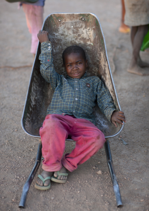 Mucawana Boy Laying Down In A Wheelbarrow, Village Of Oncocua, Angola