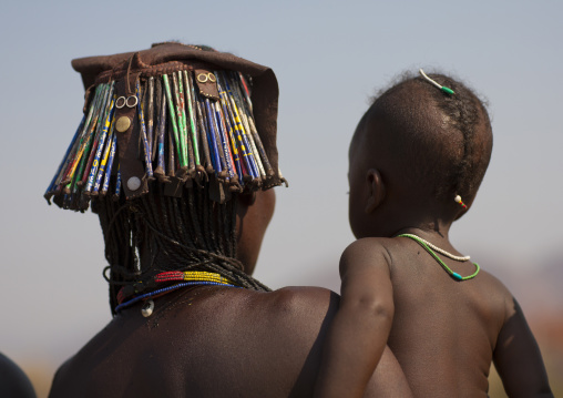 Mucawana Kid In The Arms Of His Mother Wearing The Kapapo Headdress Made Of Waste Materials, Village Of Soba, Angola