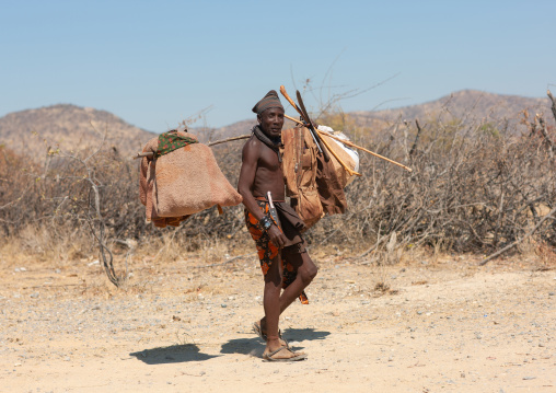 Himba tribe man carrying stuff on a road, Cunene Province, Oncocua, Angola