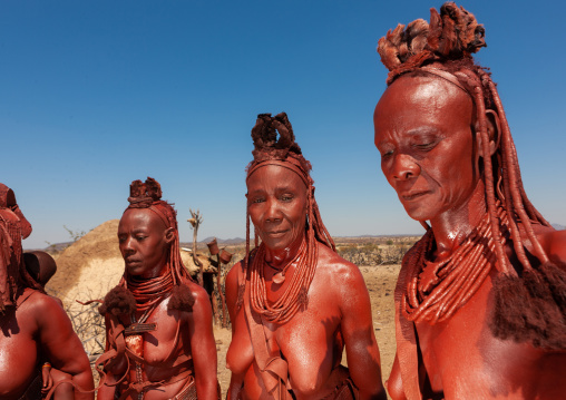 Himba tribe women covered with otjize standing in line, Cunene Province, Oncocua, Angola