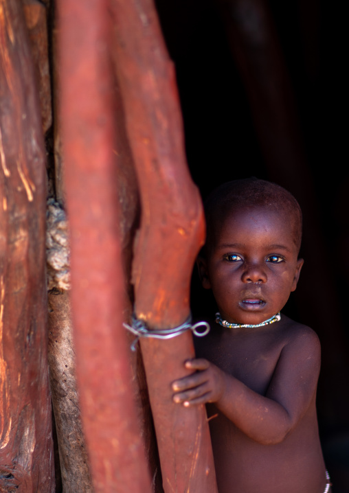 Himba tribe boy in a wooden hut, Cunene Province, Oncocua, Angola