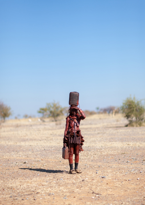 Himba tribe woman carrying a jerrycan on head, Cunene Province, Oncocua, Angola