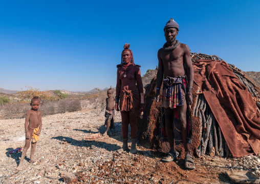 Himba tribe family in front their hut, Cunene Province, Oncocua, Angola