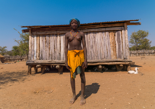 Portrait of a Muhacaona tribe woman in front of a wooden house, Cunene Province, Oncocua, Angola