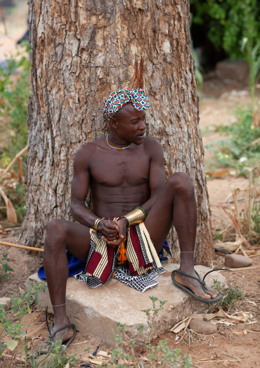 Portrait of a Mucubal tribe man sit near a tree, Namibe Province, Virei, Angola