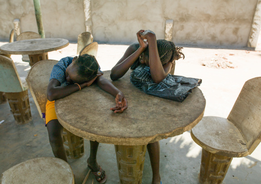 Angolan girls sleeping on a table restaurant, Namibe Province, Namibe, Angola