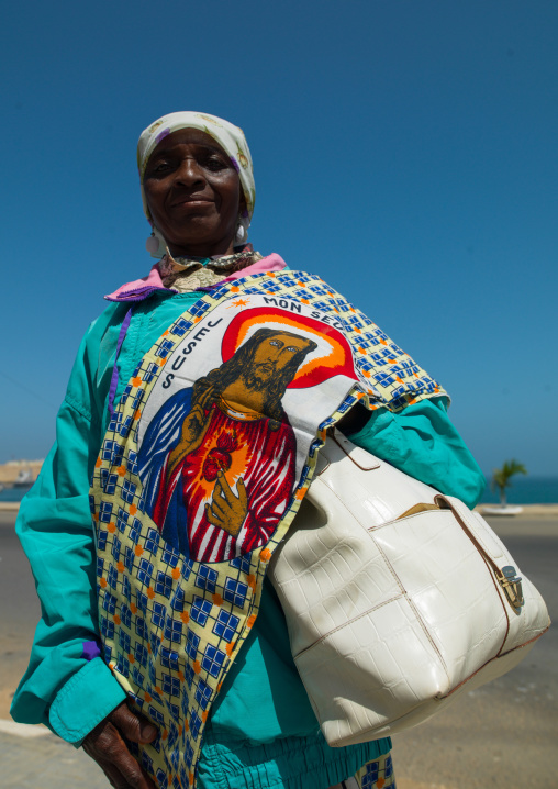 Angolan woman selling a loincloth decorated with jesus, Namibe Province, Namibe, Angola