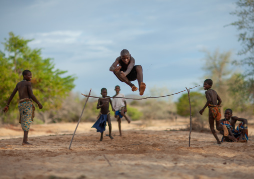 Mucubal tribe boys doing high jumping in the bush, Namibe Province, Virei, Angola