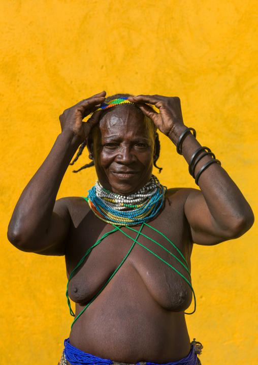 Mumuhuila tribe woman ajusting her beaded headwear, Huila Province, Chibia, Angola
