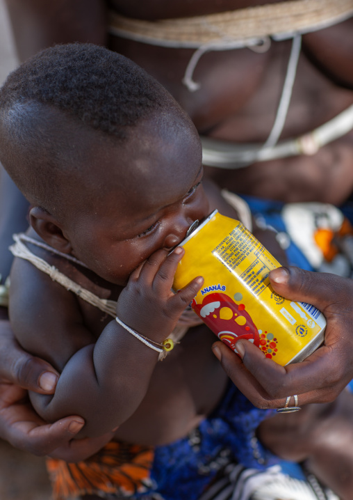 Mucubal tribe child drinking a soda, Namibe Province, Virei, Angola