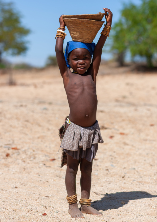 Mucubal tribe girl carrying a basket on head, Namibe Province, Virei, Angola