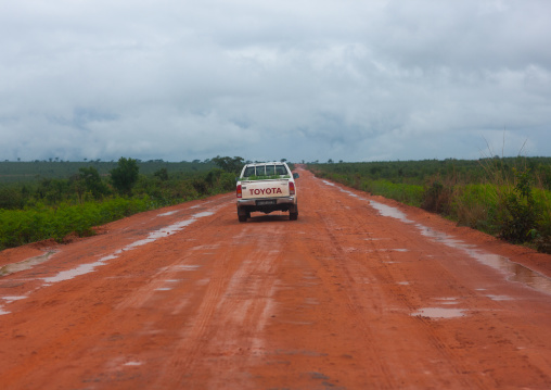 Car driving on a dirt road in the bush, Bié Province, Kuito, Angola