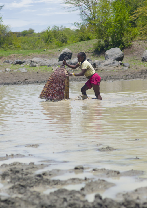 Girl Fishing In The River With A Basket Net, Angola