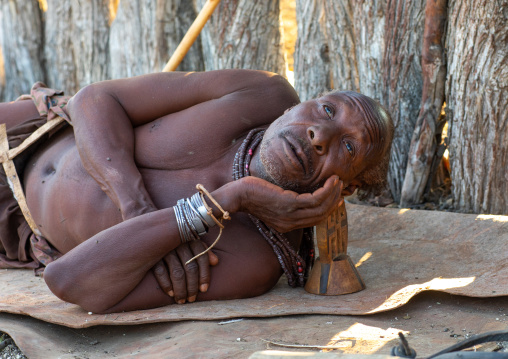 Himba tribe old man resting with his wooden pillow, Cunene Province, Oncocua, Angola