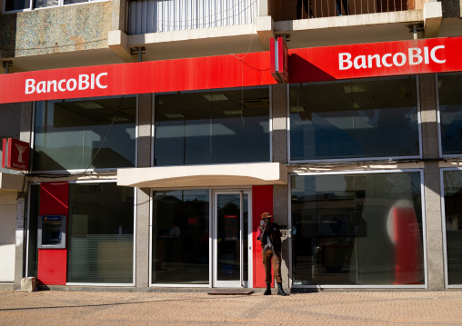 Security guard standing in front of the entrance of a banco Bic , Huila Province, Lubango, Angola